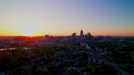 aerial footage captures a breathtaking sunset over indianapolis, indiana, showcasing the city skyline illuminated by vibrant, warm evening light.