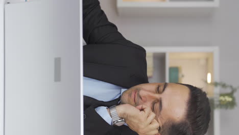 vertical video of home office worker man is tired and sleepy.