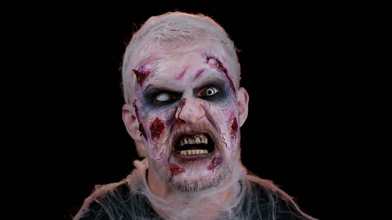 Unexpected appearance of creepy man Halloween crazy zombie with bloody wounded face trying to scare