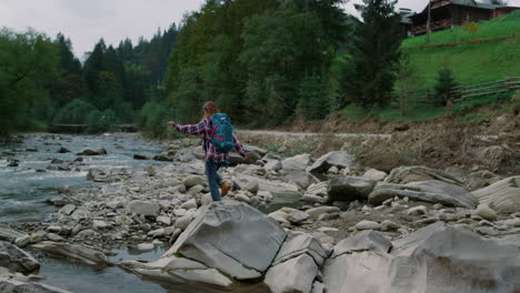 hiker walking on rocks at river