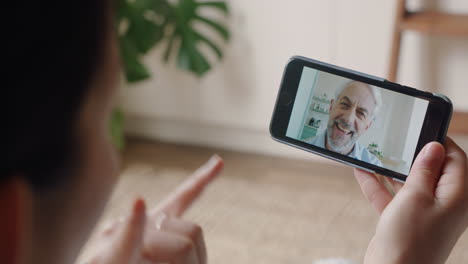 mujer joven usando un teléfono inteligente hablando en video con un abuelo sordo comunicándose usando lenguaje de señas gestos con las manos disfrutando de la comunicación en línea