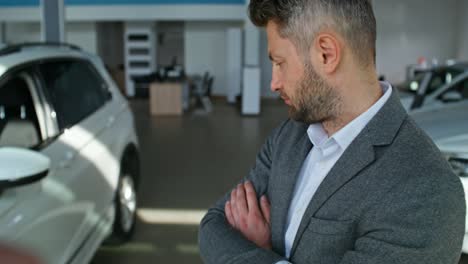 man looking at cars in a showroom