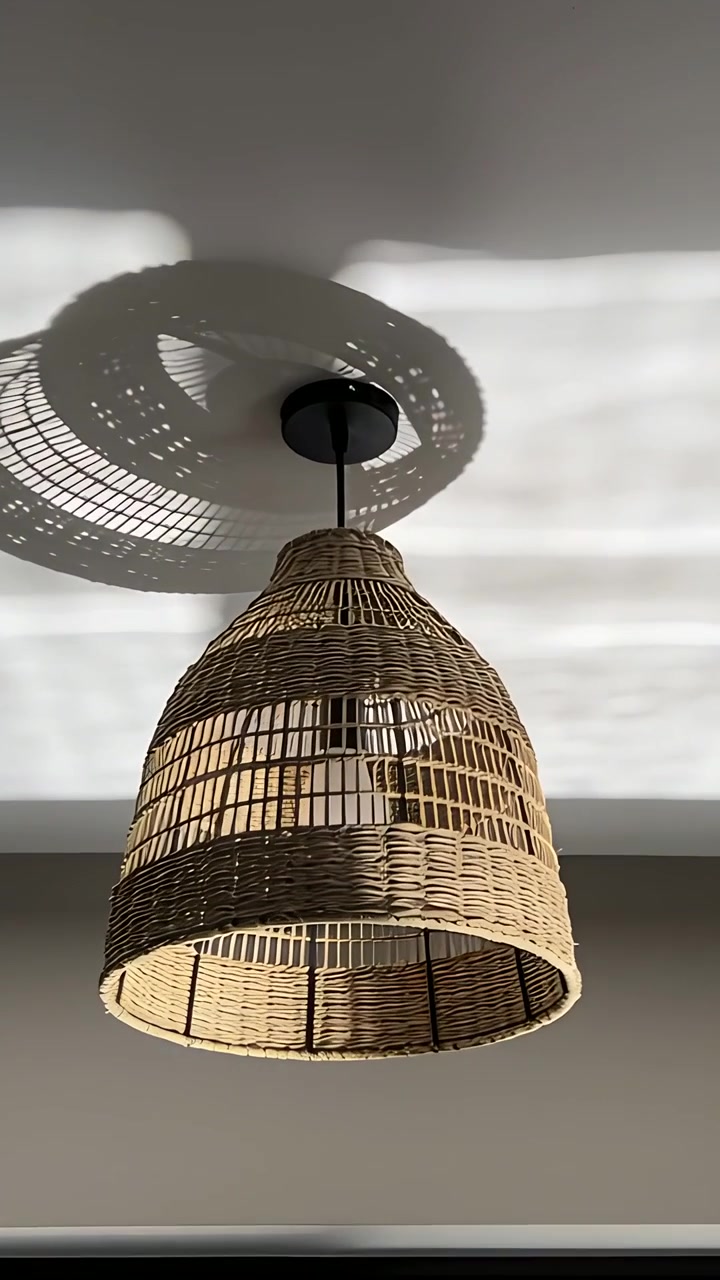 Vertikales Video: Rattanlampe wirft wandernden Schatten an die Decke, während die Sonne durchs Fenster gleitet