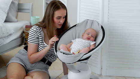 Blurred-young-woman-looking-at-a-cute-little-baby-sleep-in-bed-at-home