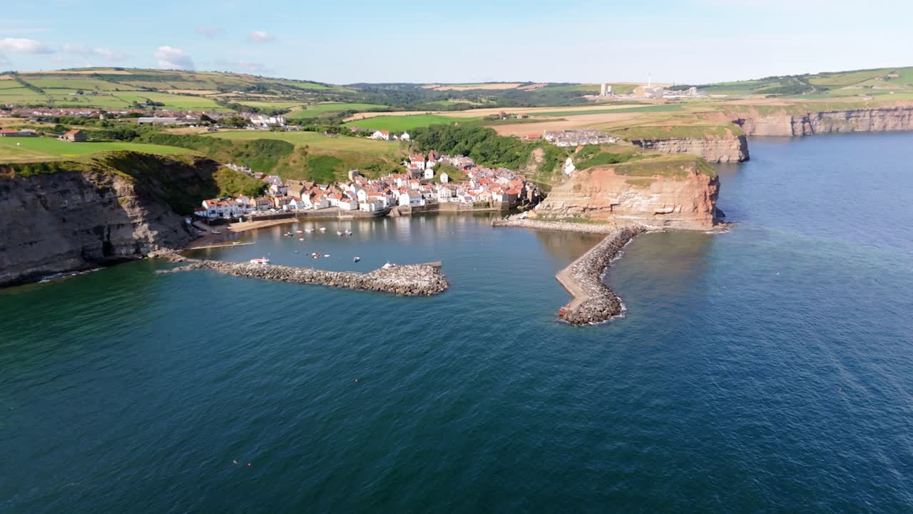 vista aérea de un dron del puerto de staithes en la costa del norte de yorkshire con el río, las casas, los barcos en una mañana soleada de agosto, verano
