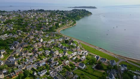 aerial drone view over perros-guirec coastal town, panoramic road, and bay with boats, brittany, france