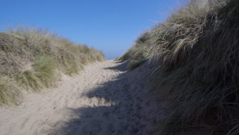 extra wide shot looking up eroded path through sand dunes at horsey beach next to winterton on sea,