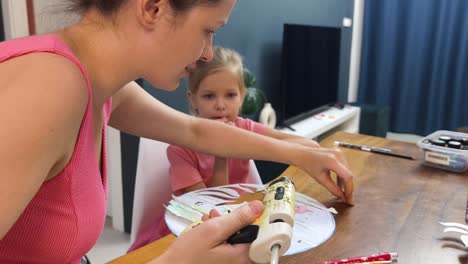 madre e hija haciendo un proyecto de artesanía juntos