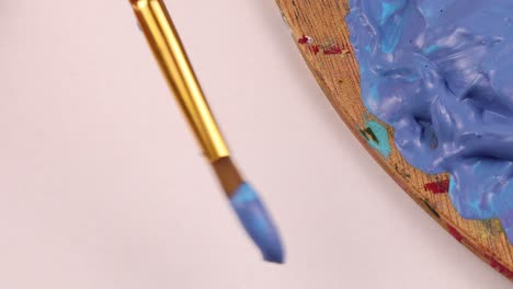 painting purple blue on paper with small paintbrush