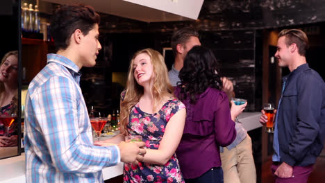 Attractive-friends-talking-and-drinking-at-the-bar