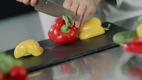 Koch-Kocht-Essen-Im-Küchenrestaurant.-Nahaufnahme-Des-Chefkochs,-Der-Rote-Paprika-Schneidet.