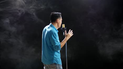 hombre cantando en un micrófono en el escenario