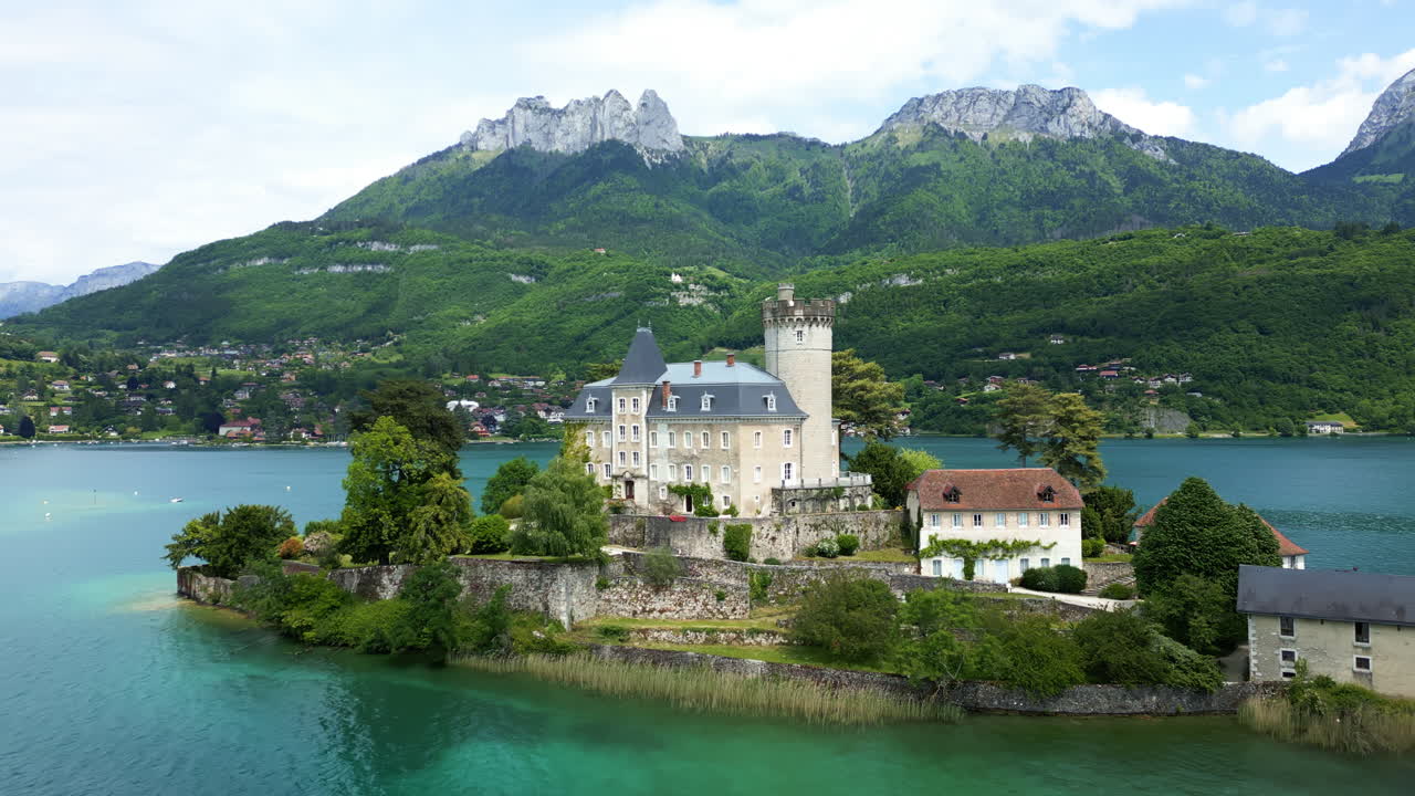 Push in drone shot of Duingt Castle during the day with Lake Annecy in Haute-Savoie, France