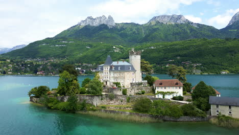 push in drone shot of duingt castle during the day with lake annecy in haute-savoie, france