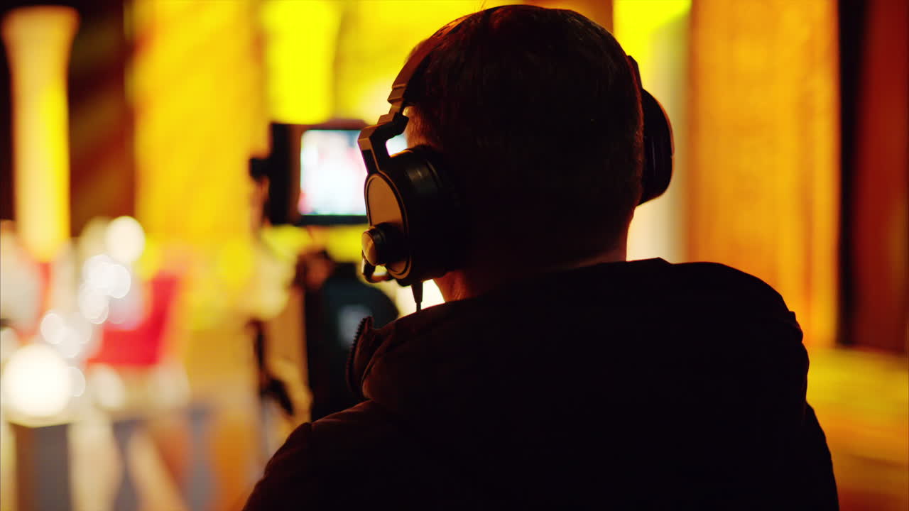 Man filming with professional camera on the backstage of a TV set