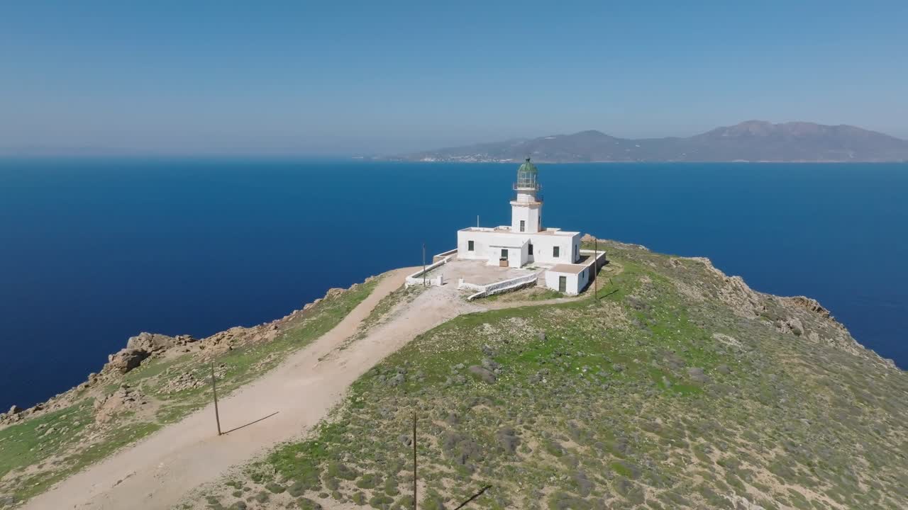 Cinematic orbit and ascend around a lighthouse, revealing the surrounding landscape and the deep blue sea