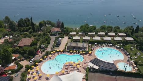 Toma-Aérea-De-La-Piscina-En-El-Camping-Europa-Silvella-Cerca-Del-Lago-De-Garda,-Italia