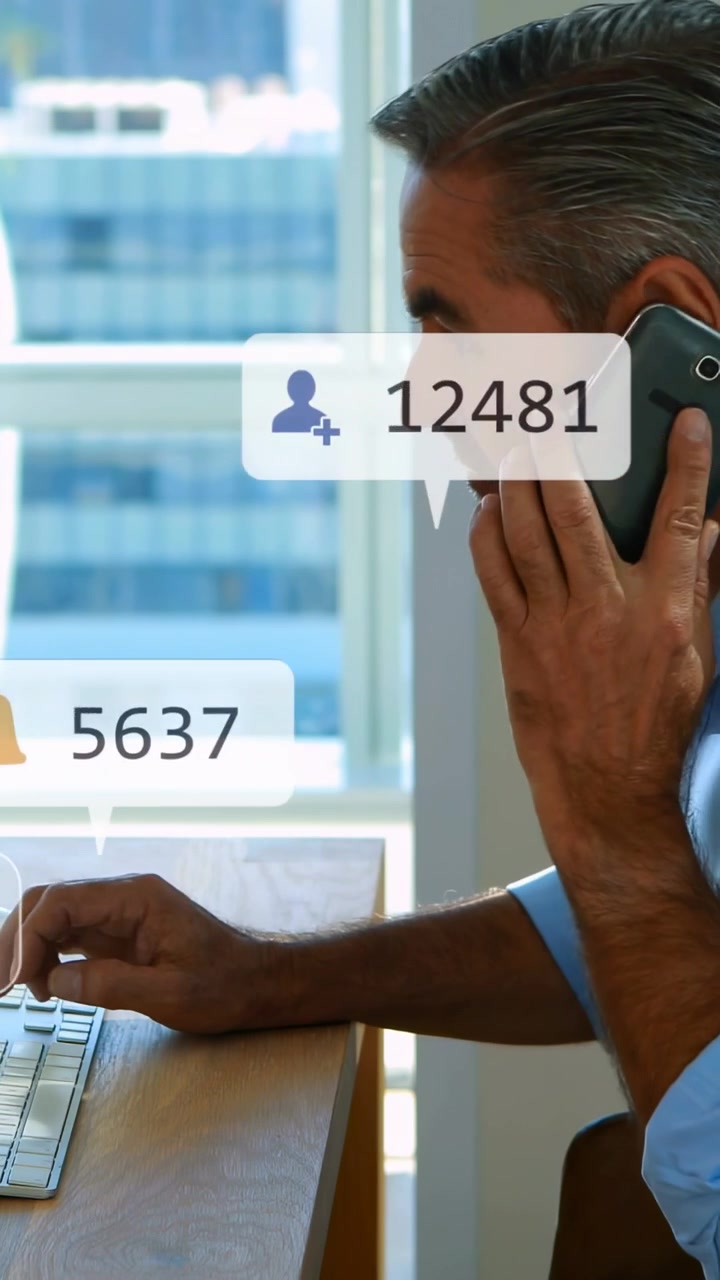 Vertical video: worker typing, social alerts popping over hands, reaching phone and typing for work