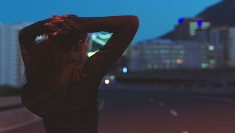 woman stretching at night in the city