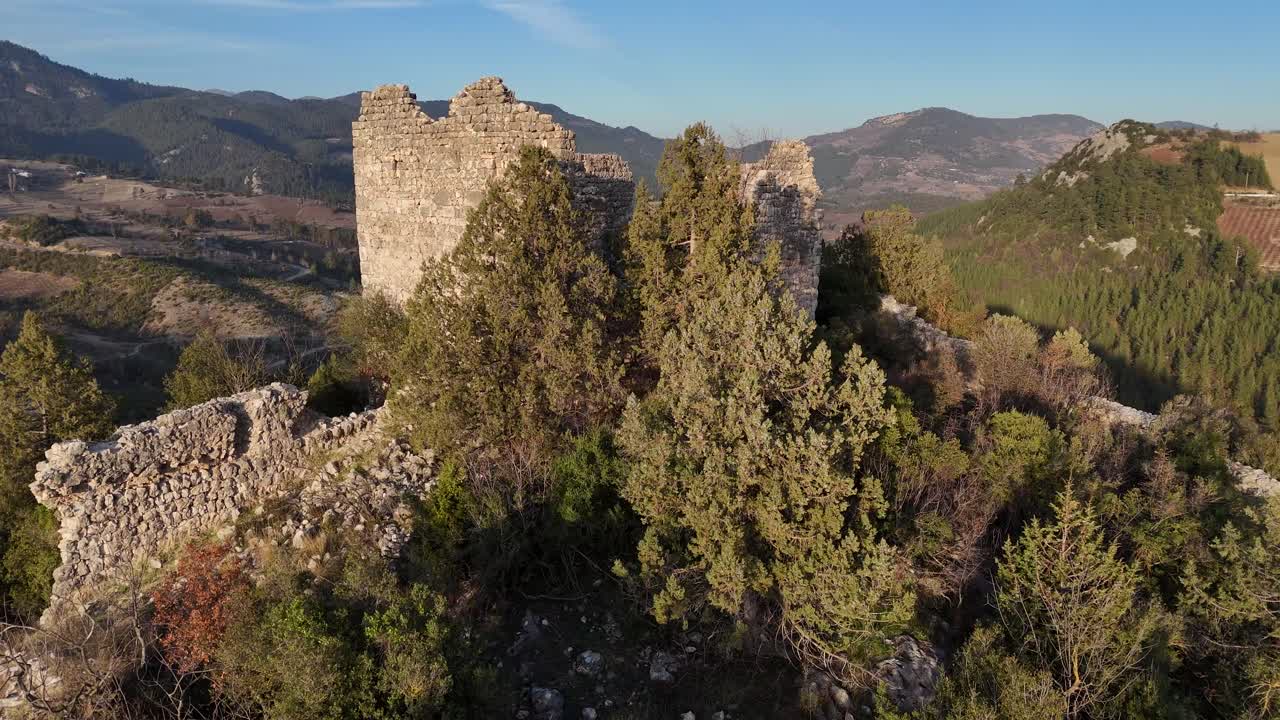 La bandiera in cima all'edificio del castello tra gli alberi sulla cima della montagna, Castello di Belenkeşlik.