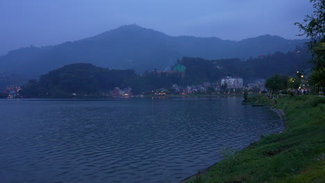 Una-Tarde-Junto-Al-Lago-Fea-En-Pokhara-Nepal-Mientras-El-Sol-Se-Ha-Puesto-Y-La-Oscuridad-Cae-Y-Las-Luces-De-La-Ciudad-Se-Encienden