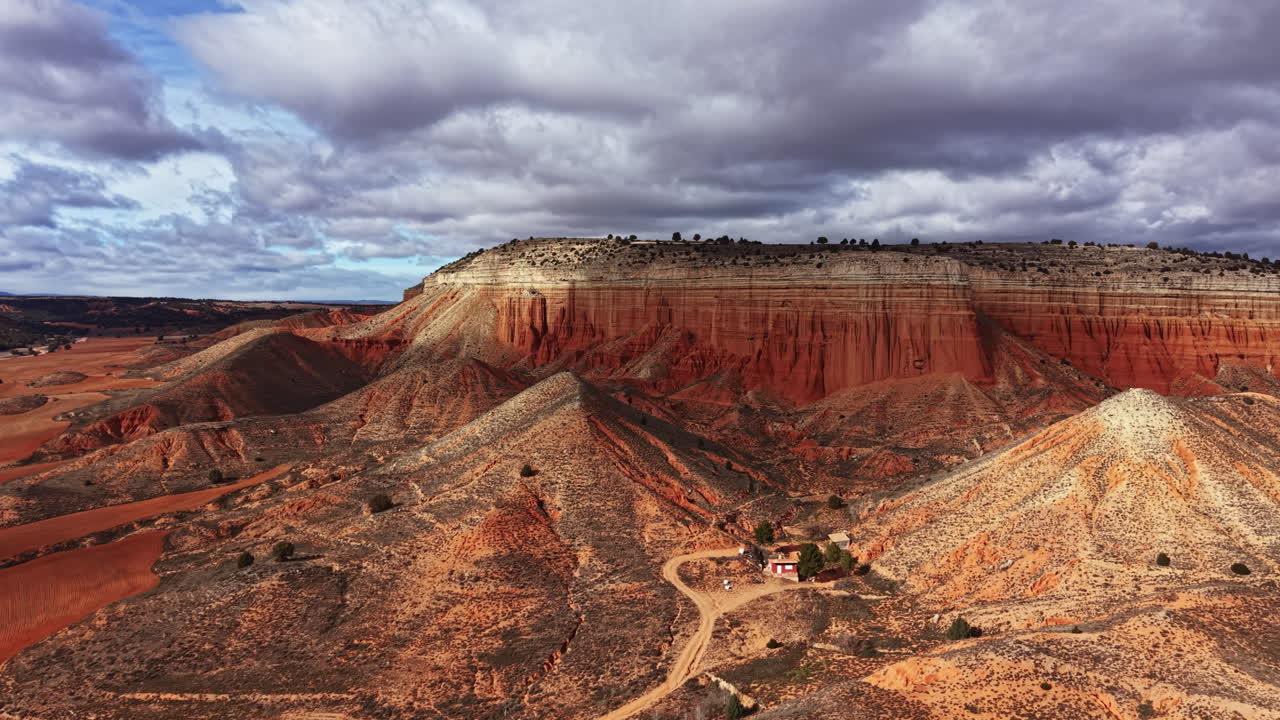 View of canyon landscape with rock formations and sky covered in clouds during the day in a remote area