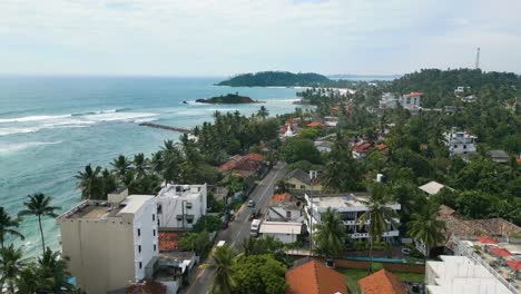 Toma-Aérea-De-Una-Carretera-En-Un-Pueblo-Costero-Junto-A-La-Playa-En-Sri-Lanka,-Mirissa