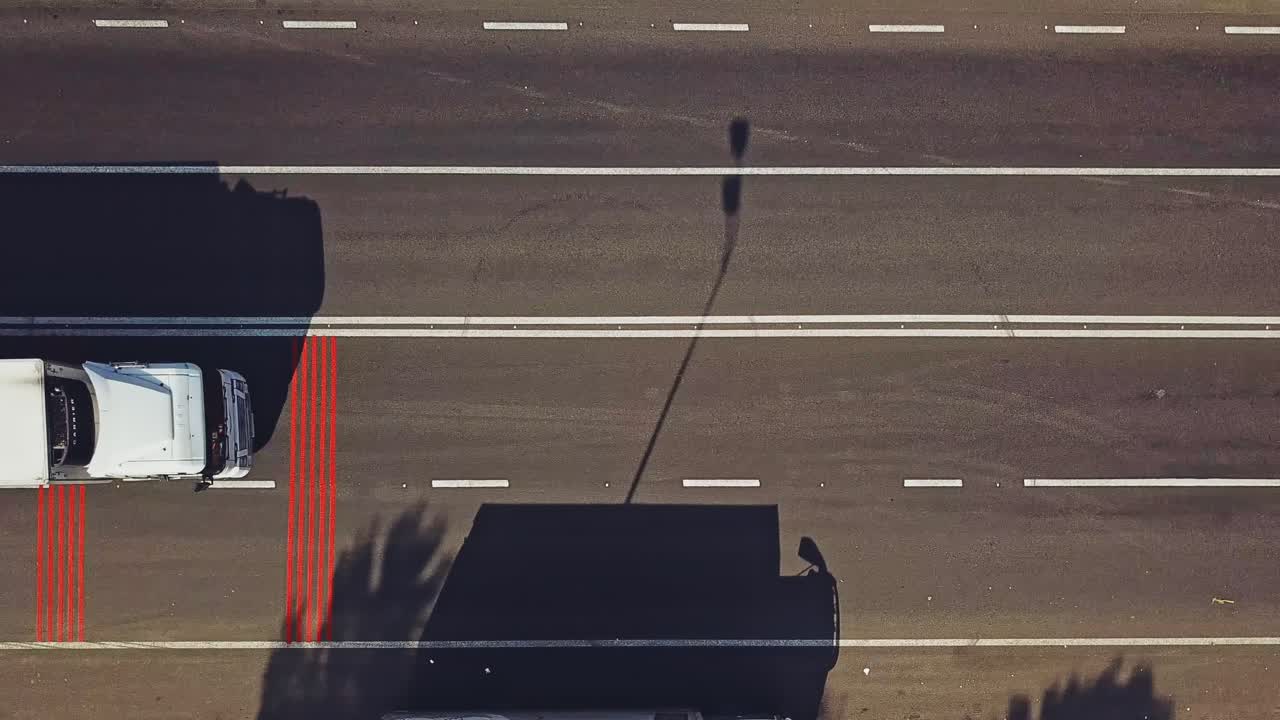 Zebra crossing painted brightly red and white with the cars on it moving. Pedestrian crossing and some red vertical lines written before on the road. Aerial view. Motion Left.