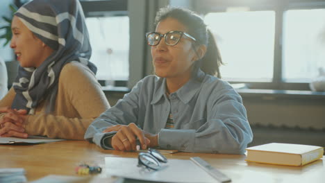 cheerful woman chatting with group mates on english class for immigrants