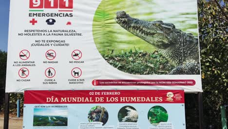 Warning-and-wildlife-sign-at-Las-Garzas-Lagoon-in-Manzanillo,-Colima,-Mexico