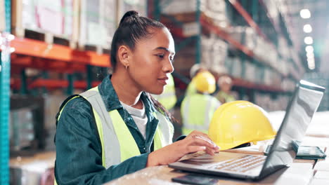 woman working on laptop in a warehouse