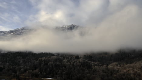 Lapso-De-Tiempo-De-Nubes-Bajas-En-Un-Valle-Que-Se-Aclara-Lentamente-Para-Revelar-Las-Cimas-De-Las-Montañas-En-El-Fondo