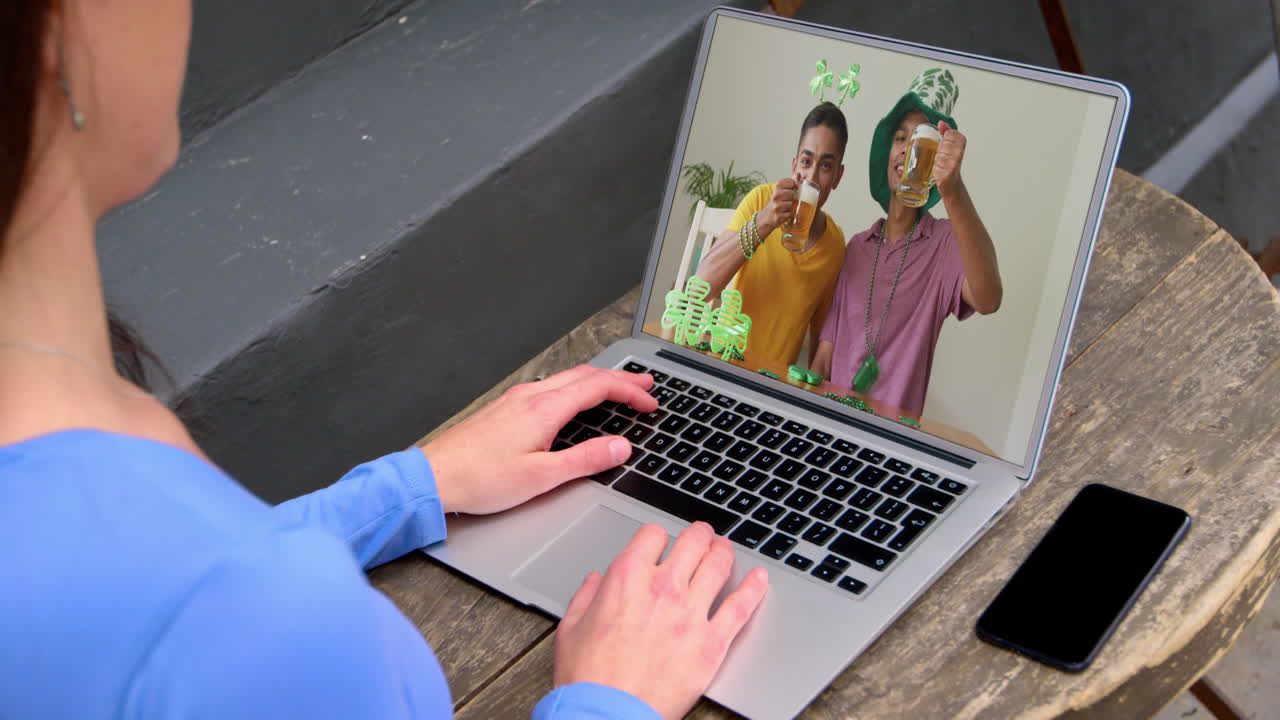 Caucasian woman at home using laptop making video call on st patrick's day
