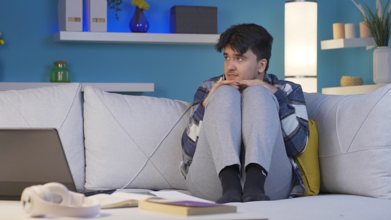 밤에 집에서 혼자 두려워하고 주위를 둘러보는 남자.