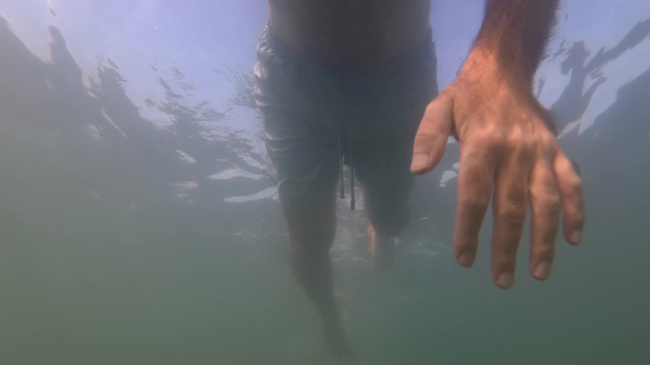 Undervandsudsigt af en mands ben, mens han svømmer i havet, Golfe-Juan, Frankrig