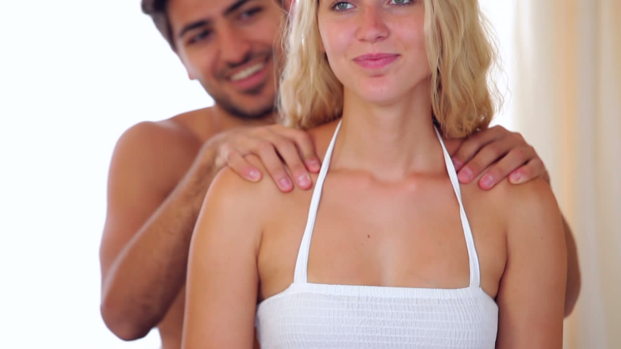 hombre dando un masaje a su novia rubia