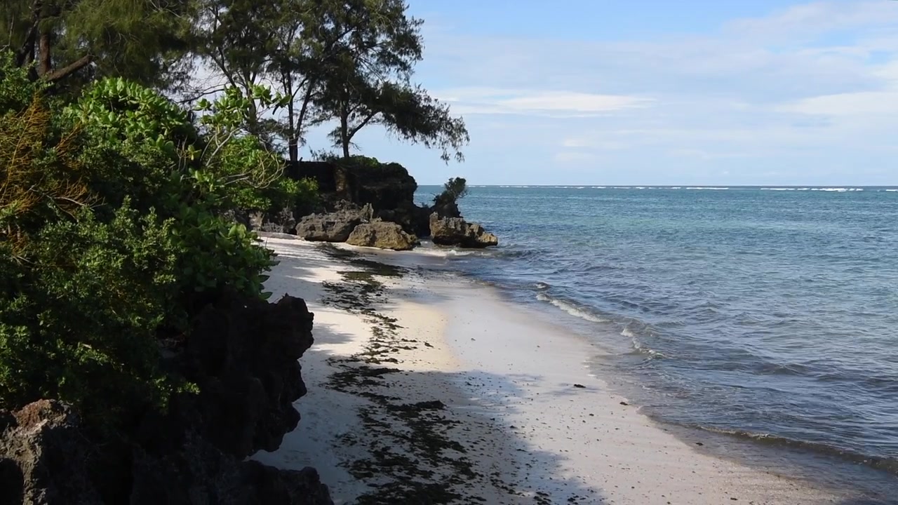 White sand covers a tropical beach on the Indian Ocean in Kilifi, Kenya.