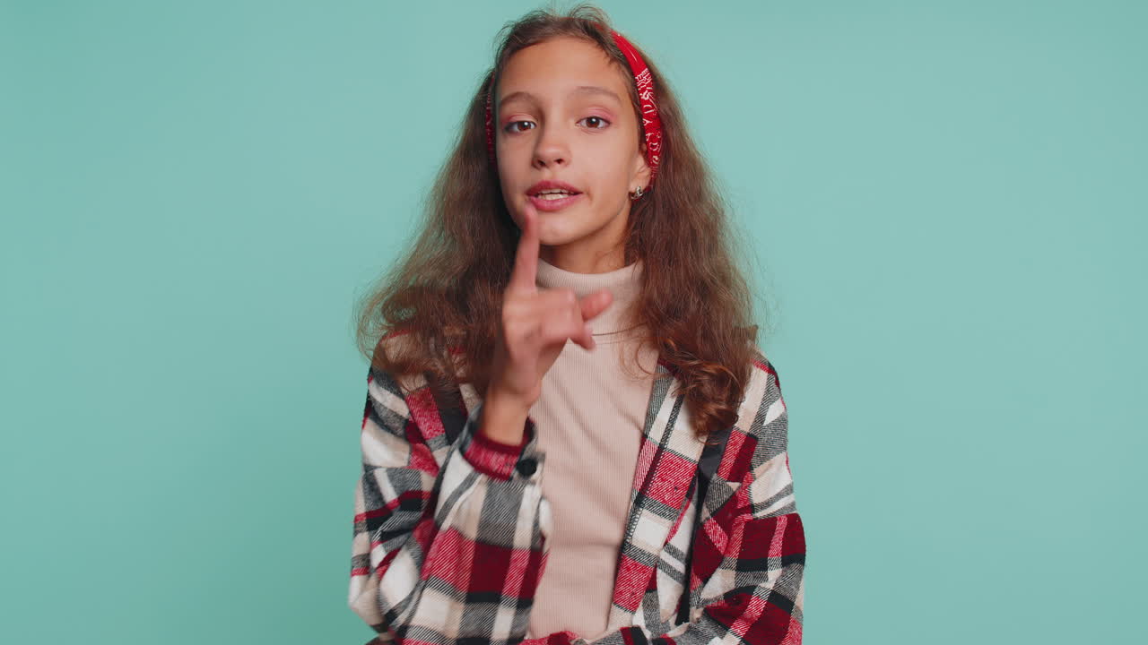 niña preadolescente presiona el dedo a los labios hace silencio signo de silencio no dice chismes secreto, tranquilo