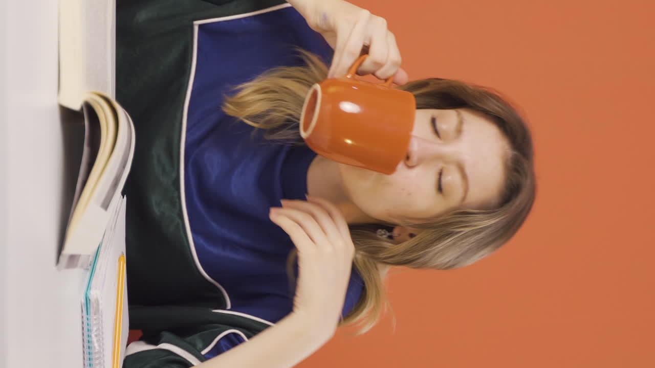 Vertical video of The young woman's mouth is burning from the hot drink.
