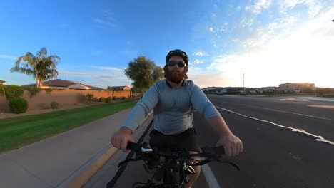 zoom de un hombre pelirrojo montando una bicicleta eléctrica en la mañana