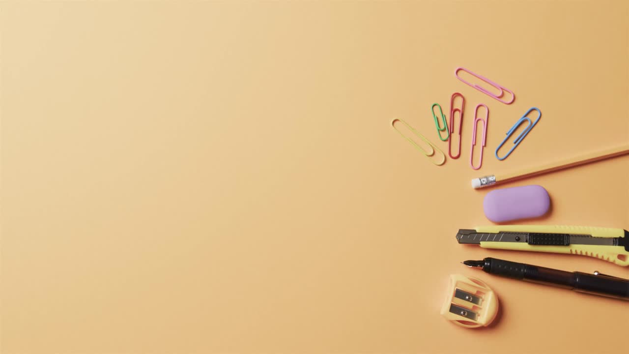 vista aérea de la papelería escolar colorida con espacio de copia sobre fondo beige, en cámara lenta