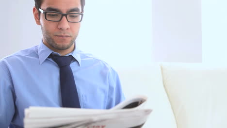 businessman reading a newspaper on a couch