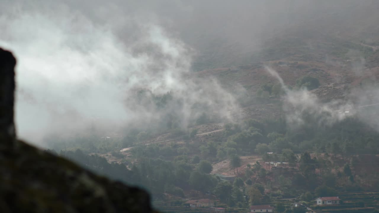 4K timelapse of clouds rolling through a forested mountain range while the sun peeks through from time to time