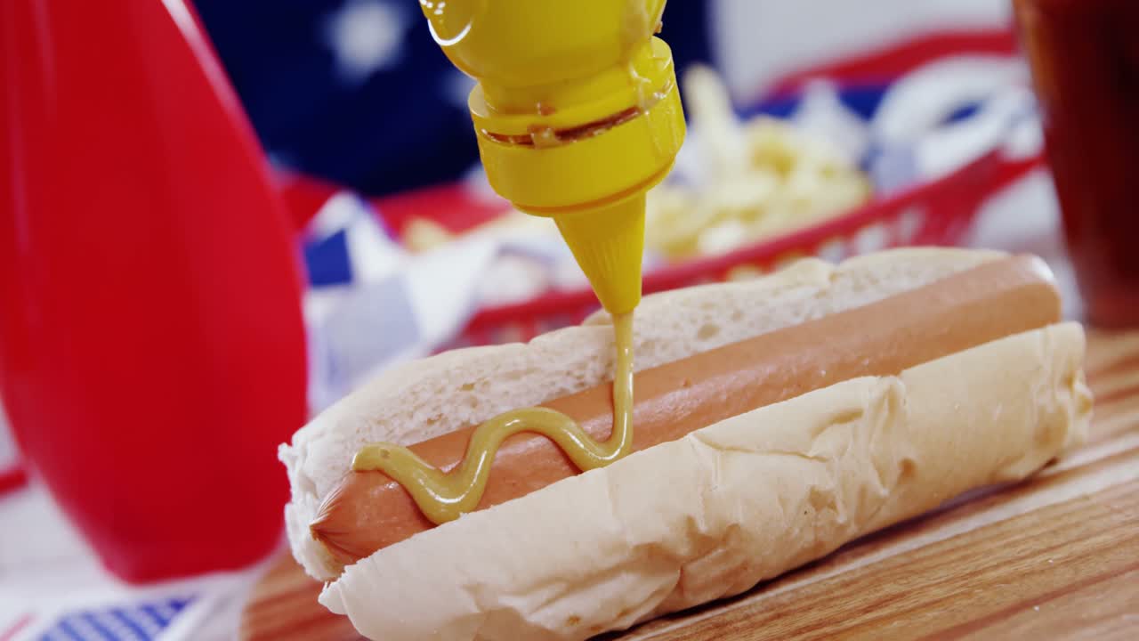 Hot dog with mustard sauce on wooden board