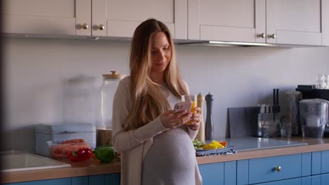 Schwangere-Frau-Trinkt-Gesunden-Saft-Und-Benutzt-Mobiltelefon.