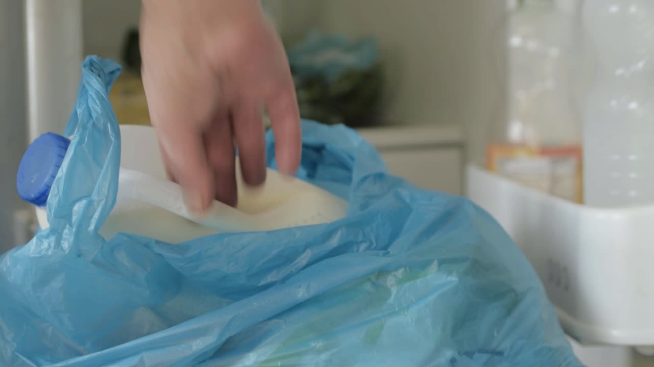 Hands putting bottle of milk into refrigerator close up shot