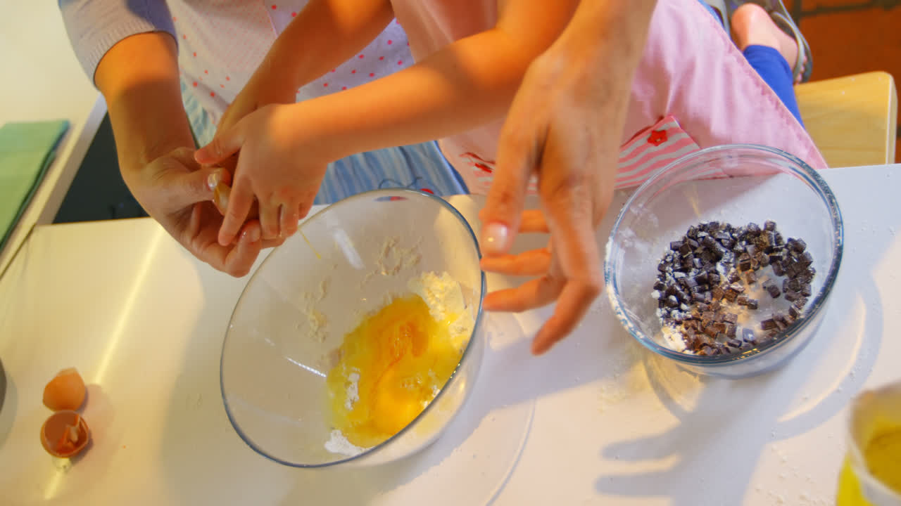 High angle view of mother and daughter baking cookies in kitchen of comfortable home 4k