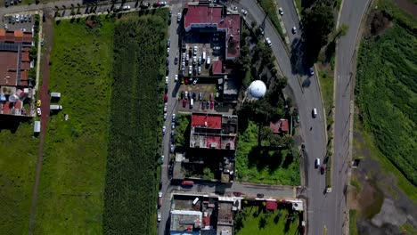 Top-drone-view-red-roofs-and-highway-in-the-charming-town-of-chalco-Mexico,-and-view-of-the-highway-town-and-houses-population-density