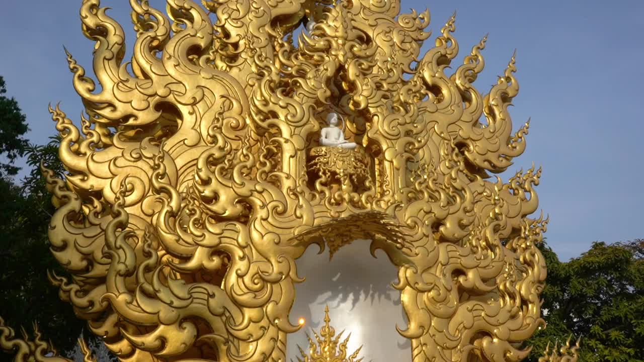 Incredible Golden flame statue with a white sitting Buddha at White Temple, Thailand.