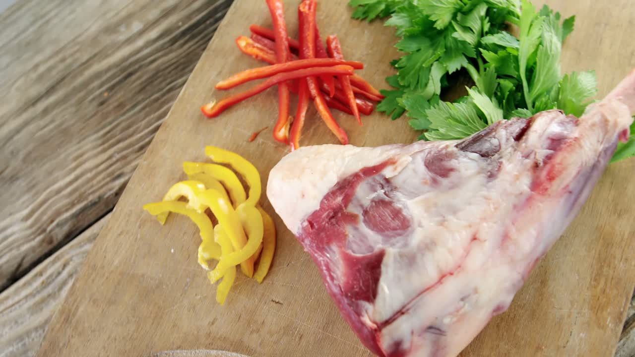 Raw meat, parsley and chopped vegetables on wooden board